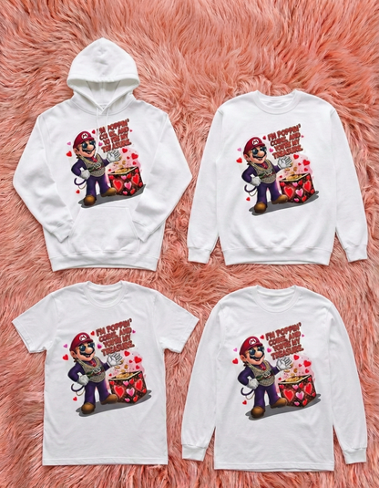 Four white shirts with a cartoon character and text on a pink fluffy background