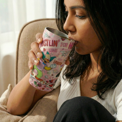 Woman drinking from a colorful mug with cartoon characters in a cozy setting.