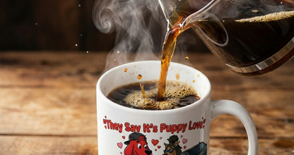 Hot coffee being poured into a mug with a cartoon design on a wooden surface