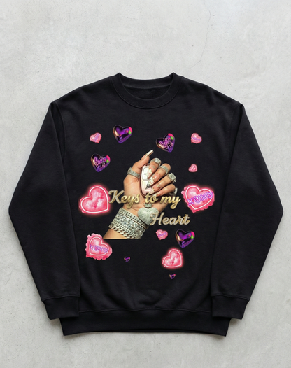 Black sweatshirt with hand holding keys design and heart shapes on a gray background