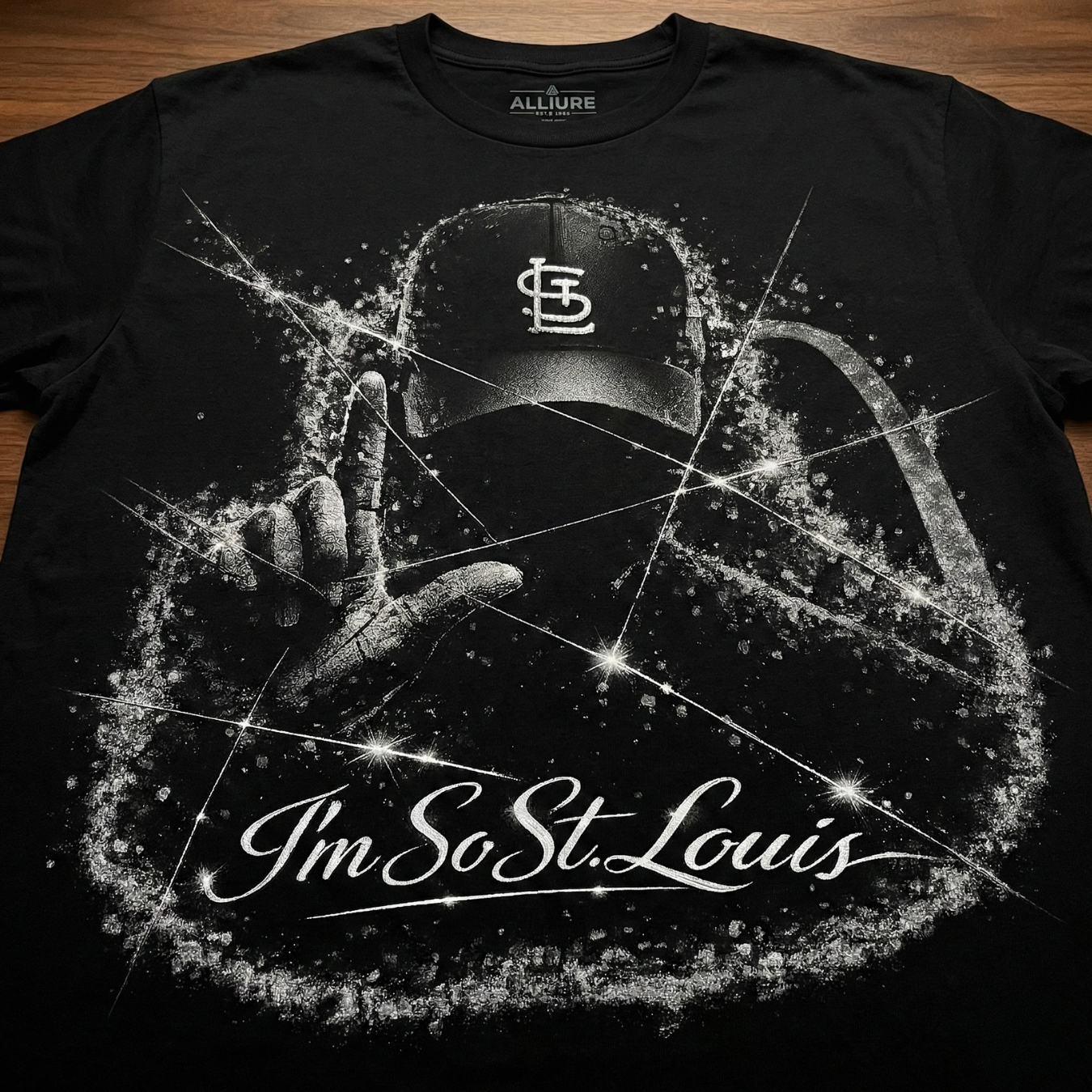 Black t-shirt with a graphic design of a hand making a peace sign, a cap, and text on a wooden surface.