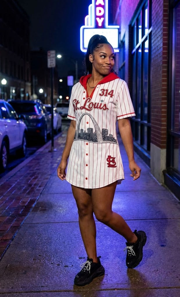 Woman wearing a St. Louis Cardinals jersey dress on a city street at night.