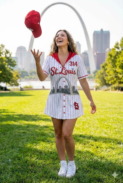 Woman in a St. Louis-themed dress and cap standing in front of the Gateway Arch.
